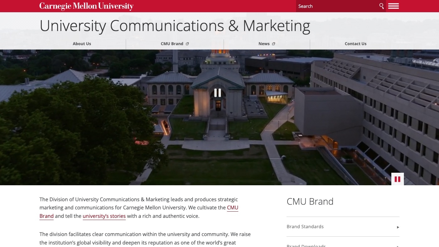 The University Communications & Marketing home page at desktop width. A translucent title bar with four section links sits over a wide aerial photograph of the campus at dusk. Intro text begins below, with a CMU Brand menu on the right.